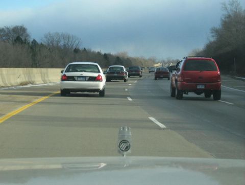1988 Mercury Grand Marquis - Several vehicles travel down the highway under a cloudy sky.