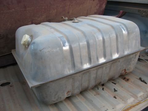 1978 Ford Bronco - A large, rectangular metal fuel tank with a ribbed surface is shown, resting in the bed of a vehicle.