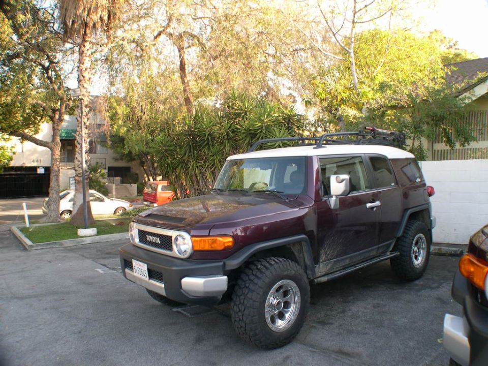 Dark purple 2007 Toyota FJ Cruiser with white roof and roof rack parked on asphalt