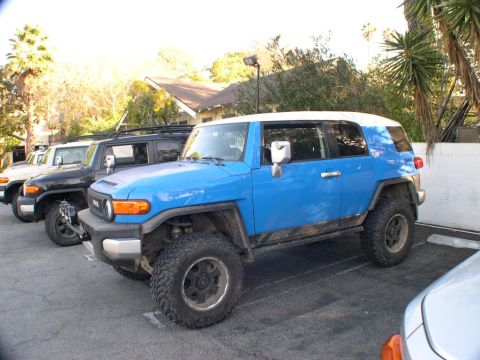 2007 Toyota FJ Cruiser - A blue 2007 Toyota FJ Cruiser with a white roof is parked in a lot alongside other vehicles.