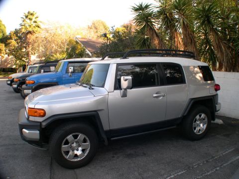 2007 Toyota FJ Cruiser - Multiple Toyota FJ Cruisers parked in a row, with the closest one being silver.