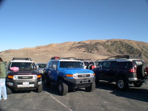 2007 Toyota FJ Cruiser - Three Toyota FJ Cruisers are parked together on a sunny day with hills in the background.