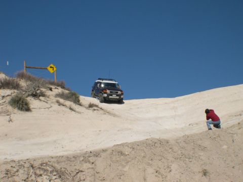 2007 Toyota FJ Cruiser - FJ Cruiser navigates a sandy hill, observed by a photographer.