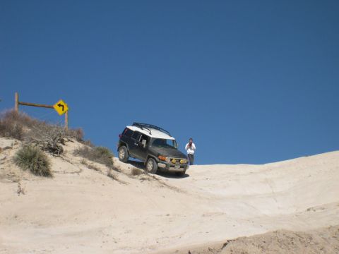 2007 Toyota FJ Cruiser - FJ Cruiser navigates a sandy incline under a clear blue sky.