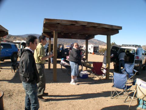 2007 Toyota FJ Cruiser - People are gathered around vehicles and a shelter in a dry, outdoor area.