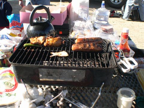2007 Toyota FJ Cruiser - Outdoor barbecue scene with food cooking on a grill, drinks, and condiments.
