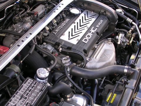 2007 Mazda 3 - Close-up view of a modified Mitsubishi engine bay a DOHC 16 valve setup and a prominent strut bar.