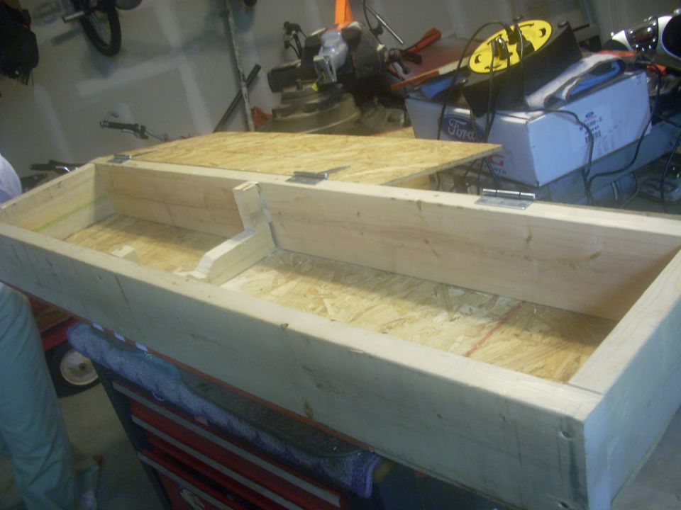 wooden storage box with hinged lid, sitting on a red toolbox