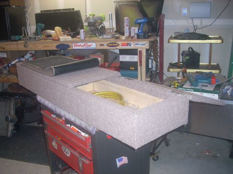 1992 Ford Bronco - Custom carpeted storage unit with a yellow hose visible inside, placed on a red toolbox.