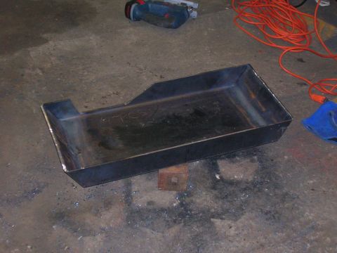 1979 Ford Bronco - Fabricated metal battery tray shown on a workshop floor with tools in the background.