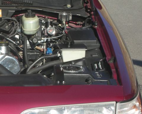1992 Ford Crown Victoria - The engine bay of a maroon 1992 Ford Crown Victoria is visible, showing the brake fluid reservoir and other engine components.