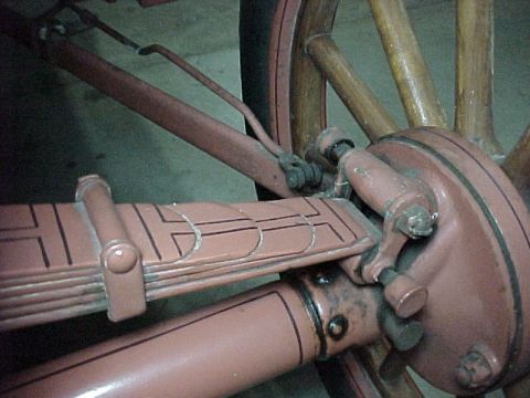 1912 Ford Model T - Detail of the suspension and wheel assembly, showing a leaf spring and hub with wooden spokes.