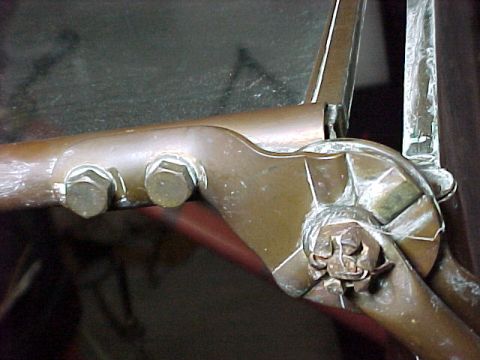 1912 Ford Model T - Detail of a vintage vehicle's door hinge, showing bolted connections and a decorative star-shaped fitting.