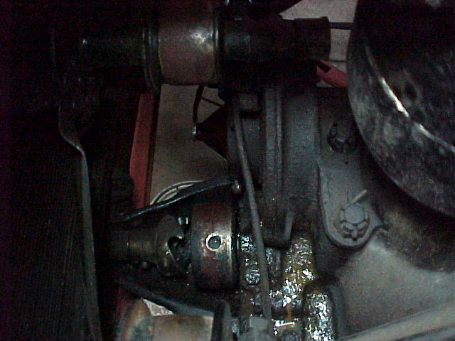 Dark under-car view of antique chassis tubes, cast housings and linkage rods
