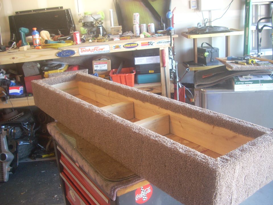 Carpeted wooden storage box with three compartments, resting on a red toolbox