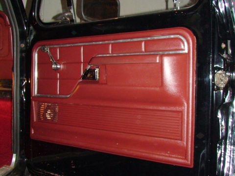 1979 Ford F-150 - The interior door panel features red upholstery with chrome accents and a speaker grille.