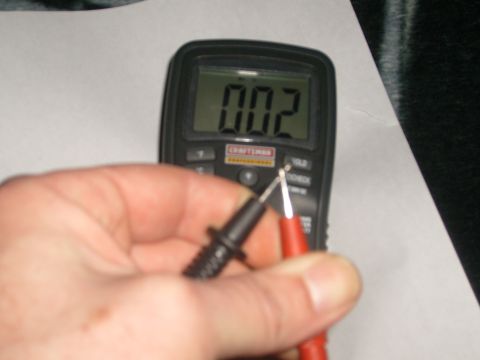 1993 Ford Bronco - A hand holds a Craftsman multimeter, showing a reading of 0.02 on its digital display.