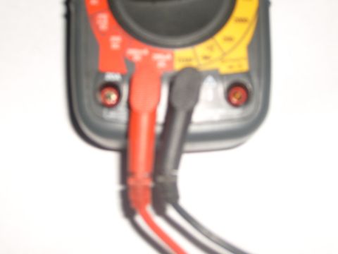 1993 Ford Bronco - Close-up of a multimeter with its red and black test leads connected.