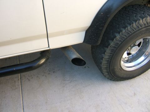 1991 Ford Bronco - Side view of an exhaust pipe and tire on a white vehicle, with a Supermotors.net watermark.