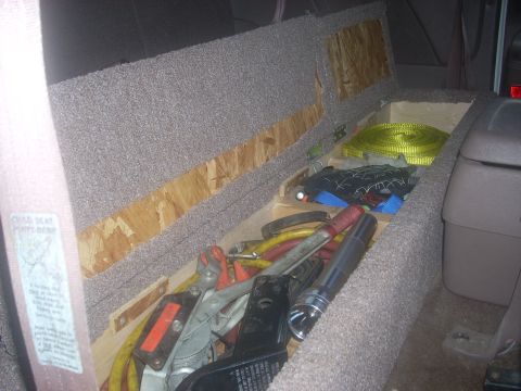 1992 Ford Bronco - This custom storage compartment is filled with various tools and a yellow strap, likely for utility or off-road use.
