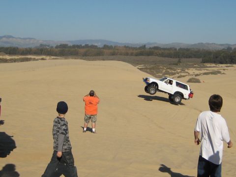 1996 Ford Bronco - White 1996 Ford Bronco catches air while driving over a sand dune.