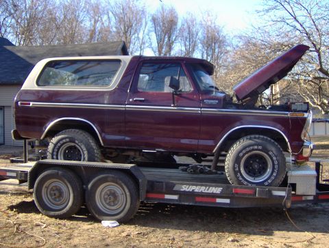 1996 Ford Bronco - This maroon Ford Bronco is on a trailer with its hood open, showing its engine bay.