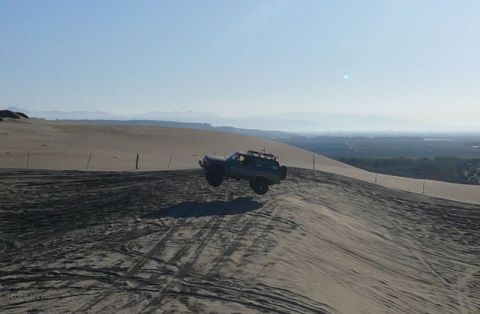 1988 Ford Bronco - This 1988 Ford Bronco is captured mid-air as it jumps over a sand dune.