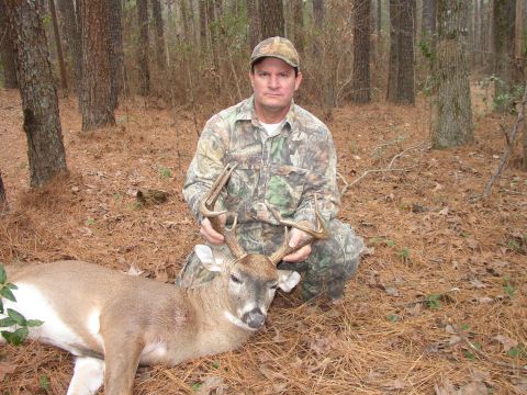 1995 Ford Bronco - Hunter poses with a harvested buck in a wooded area.