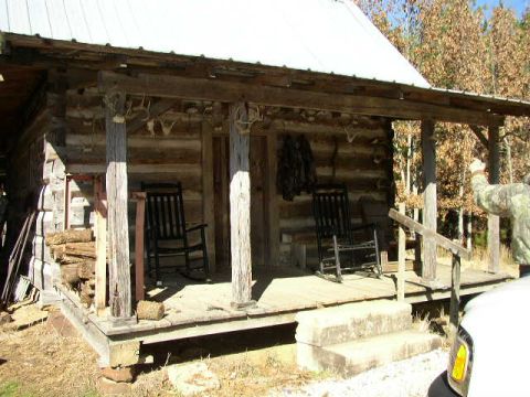 1995 Ford Bronco - A rustic log cabin porch features two rocking chairs and a person in camouflage.