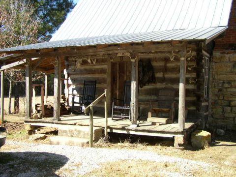 1995 Ford Bronco - A rustic log cabin porch features rocking chairs and a wooden bench, decorated with mounted antlers.