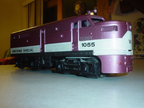 2000 Ford Crown Victoria - A toy train labeled 'TEDDY 1055' and 'VAN SONS SPECIAL' is displayed on a table.
