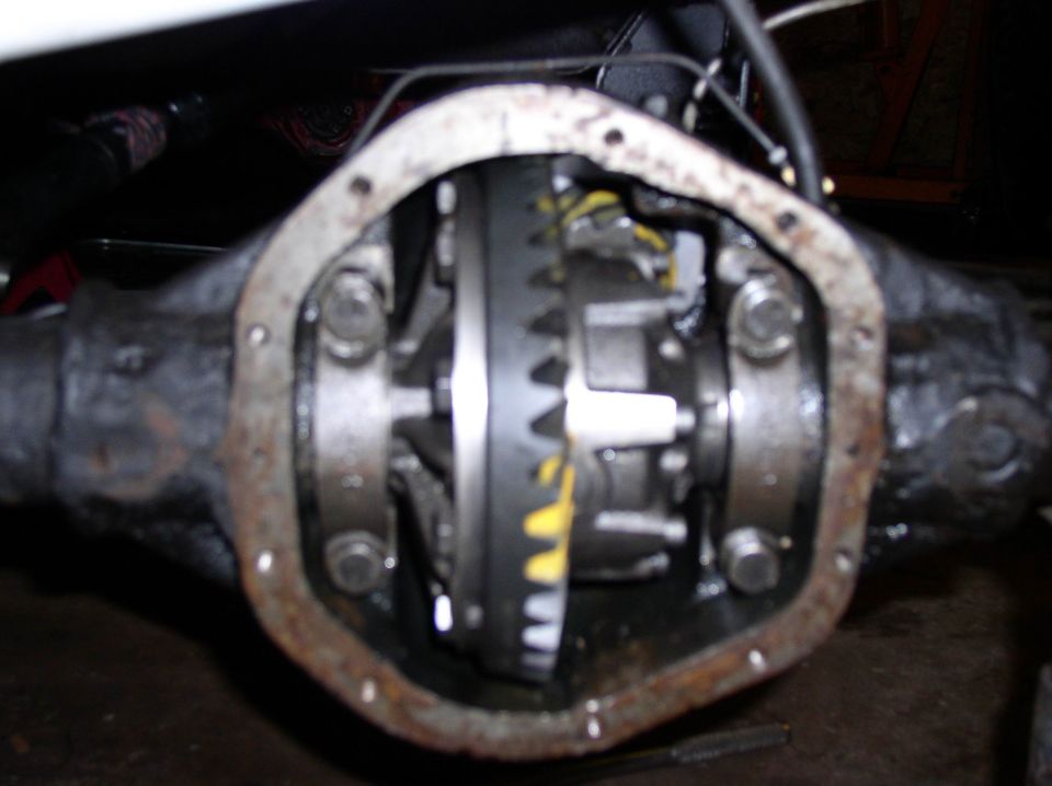Close-up of an open rear differential cover showing ring gear, carrier and bearing caps