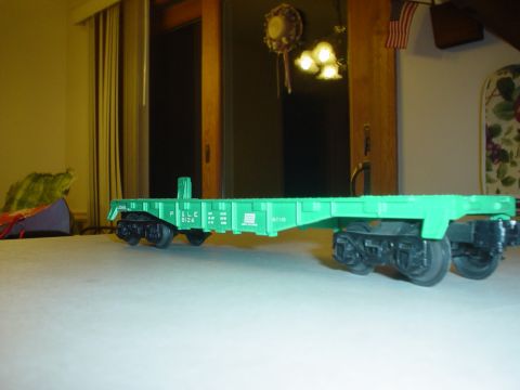 2000 Ford Crown Victoria - A close-up view of a green model train flatcar with visible text and markings.