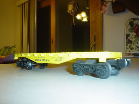 2000 Ford Crown Victoria - A model train car, painted yellow with Union Pacific markings, is shown from the side.