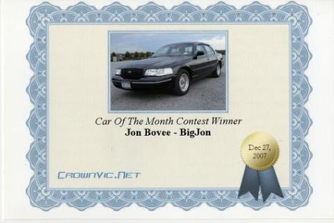 2000 Ford Crown Victoria - A certificate-style graphic showing a dark-colored Ford Crown Victoria sedan photographed from a 3/4 front angle outdoors, with text readin…