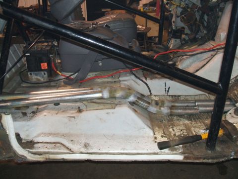 1995 Ford Bronco - Interior view of a vehicle's floor pan with a roll cage and battery visible.