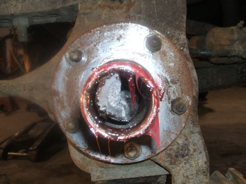 1995 Ford Bronco - Close-up of a wheel hub assembly, showing red grease and what appears to be damaged components within the hub.