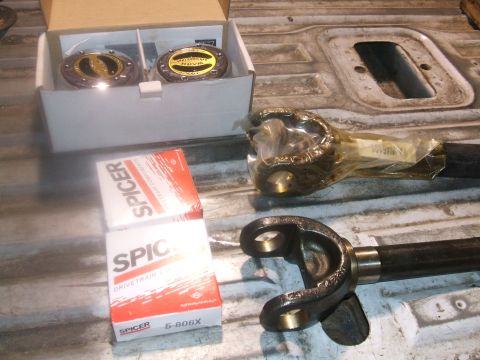 1995 Ford Bronco - Spicer U-joints and driveshaft components are laid out on a textured surface.