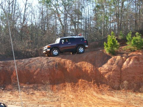 1993 Ford Bronco - A dark purple SUV navigates a challenging dirt incline, with the Supermotors logo visible in the lower right corner.