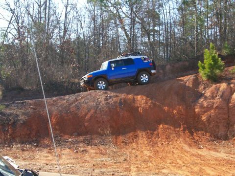 1993 Ford Bronco - Toyota FJ Cruiser navigates challenging off-road terrain on a sunny day.