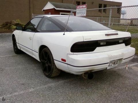1991 Nissan 240SX - Rear view of a white 1991 Nissan 240SX with tinted taillights and a large exhaust pipe.