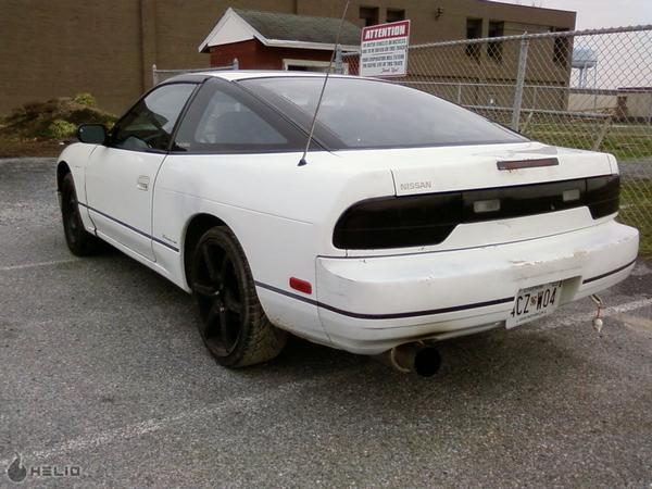 White 1991 Nissan 240SX coupe, rear view, blacked-out taillights, aftermarket exhaust, custom wheels