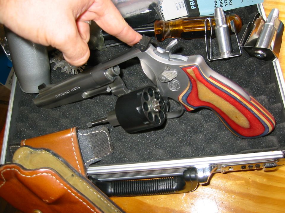 Stainless revolver with colorful laminate grips, cylinder open, in a padded aluminum case