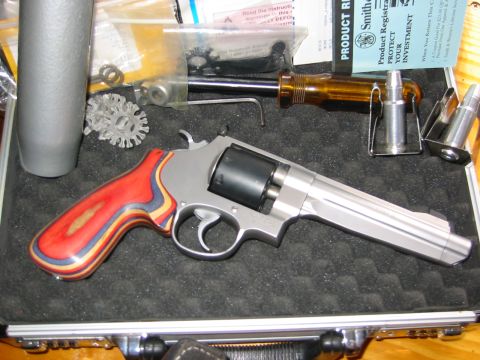1996 Ford Bronco - A revolver with distinctive layered grips is displayed with tools and ammunition, suggesting a firearm enthusiast's collection.