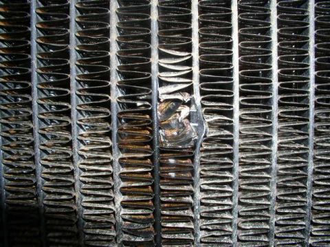 1979 Ford Bronco - Damaged radiator fins show bent metal, indicating a potential issue with the cooling system.