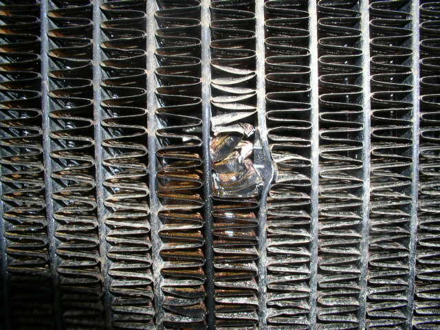 Close-up of damaged radiator fins with bent metal