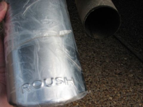 1991 Ford Bronco - A ROUSH branded exhaust tip is shown, wrapped in plastic, next to another exhaust pipe.