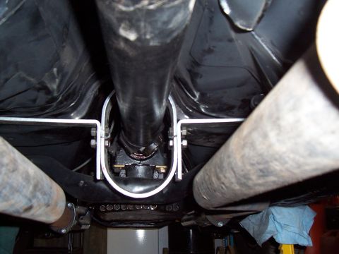 1979 Chevrolet Camaro - Close-up of the driveshaft and exhaust pipes from underneath a vehicle.