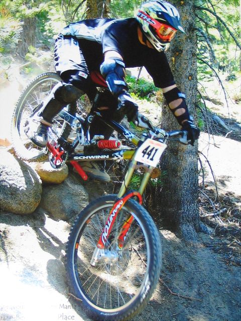 1996 Ford Bronco - A mountain biker navigates a challenging descent on a dirt and rock trail, wearing protective gear.