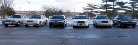 1988 Mercury Grand Marquis - Several sedans are parked in a lot, with a mix of models visible from the front.